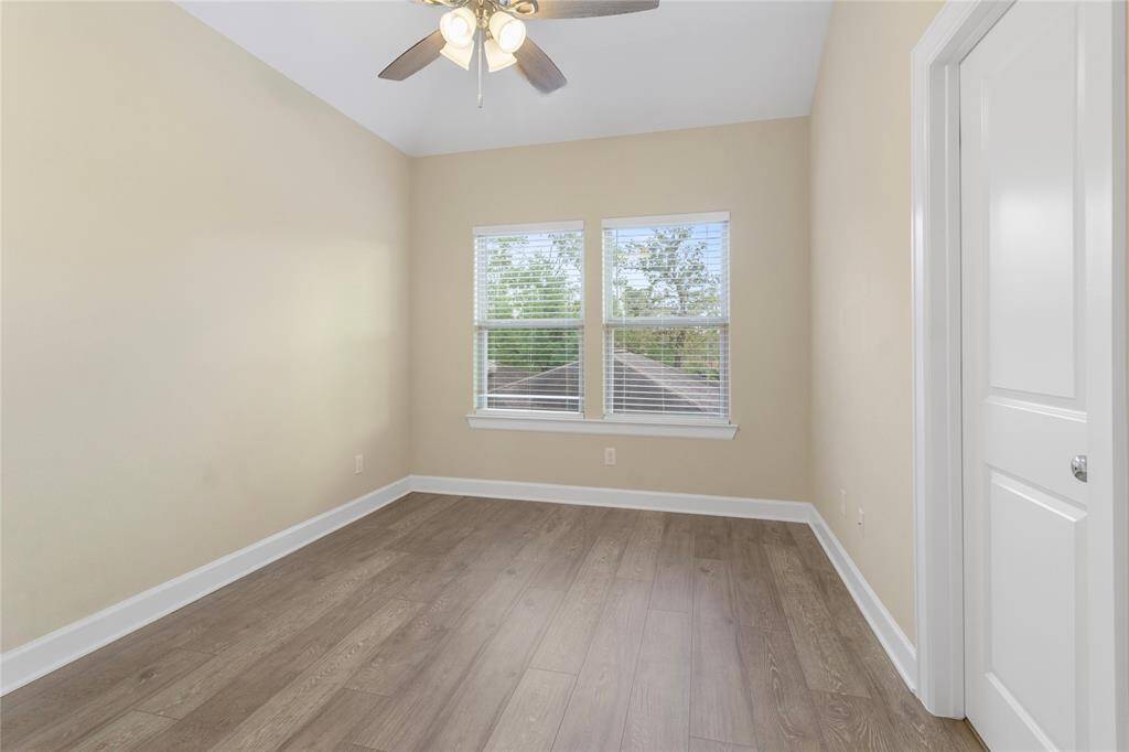 Bright bedroom with large windows and sleek wood flooring, perfect for relaxation and comfort.