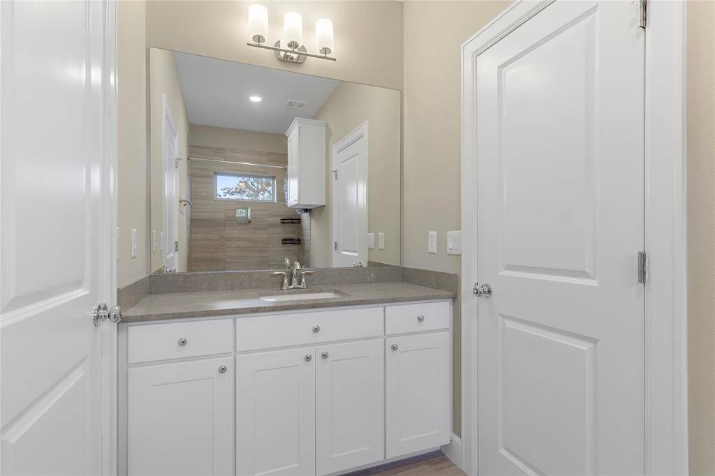 Stylish full bathroom with modern fixtures and ample storage.