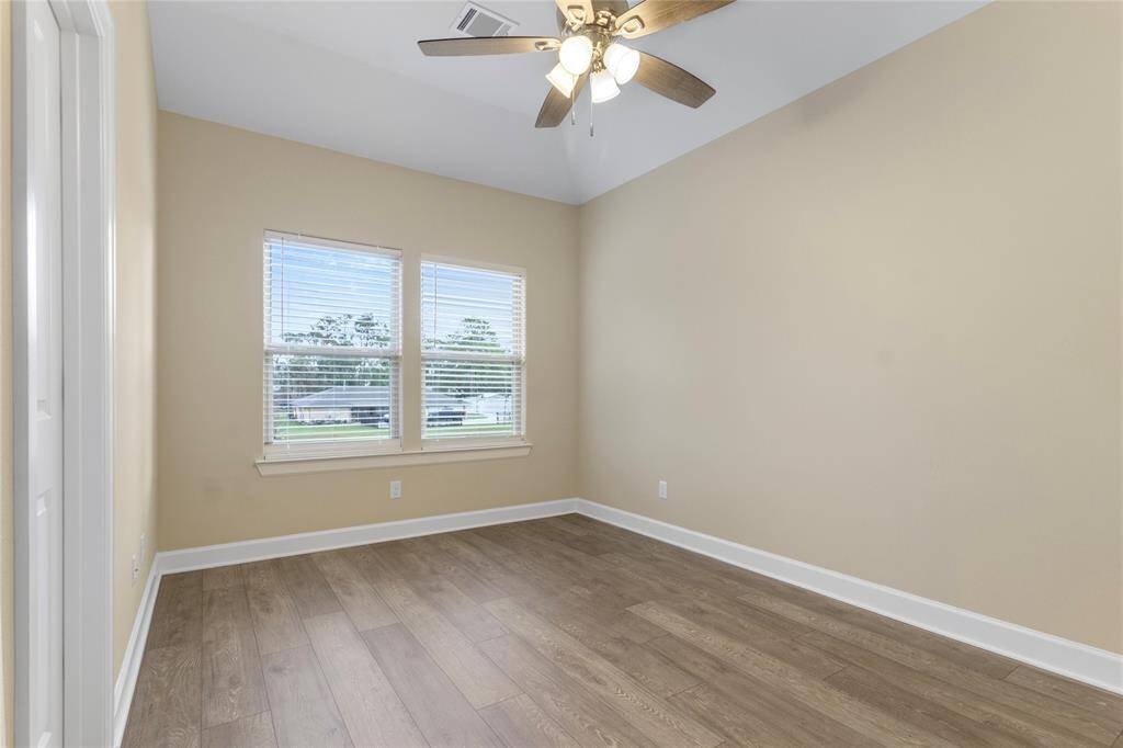 Cozy and bright, Bedroom 2 features elegant hardwood floors, ample natural light, and a ceiling fan for comfort.