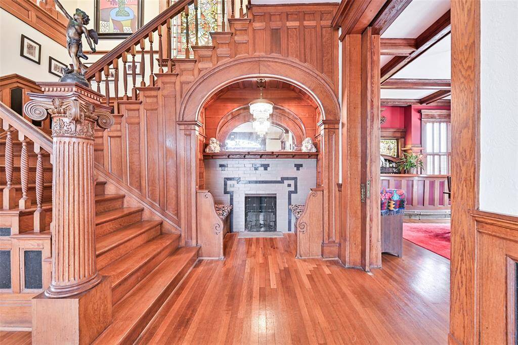 In the Tradition of Classic European Style Homes, Please Note the Fireplace with Seating in the Foyer! The Newel Post on this Classic Staircase is "Composite Style", Incorporating both Ionic and Corinthian Design, and Topped with a Cherub Carrying a Torch!