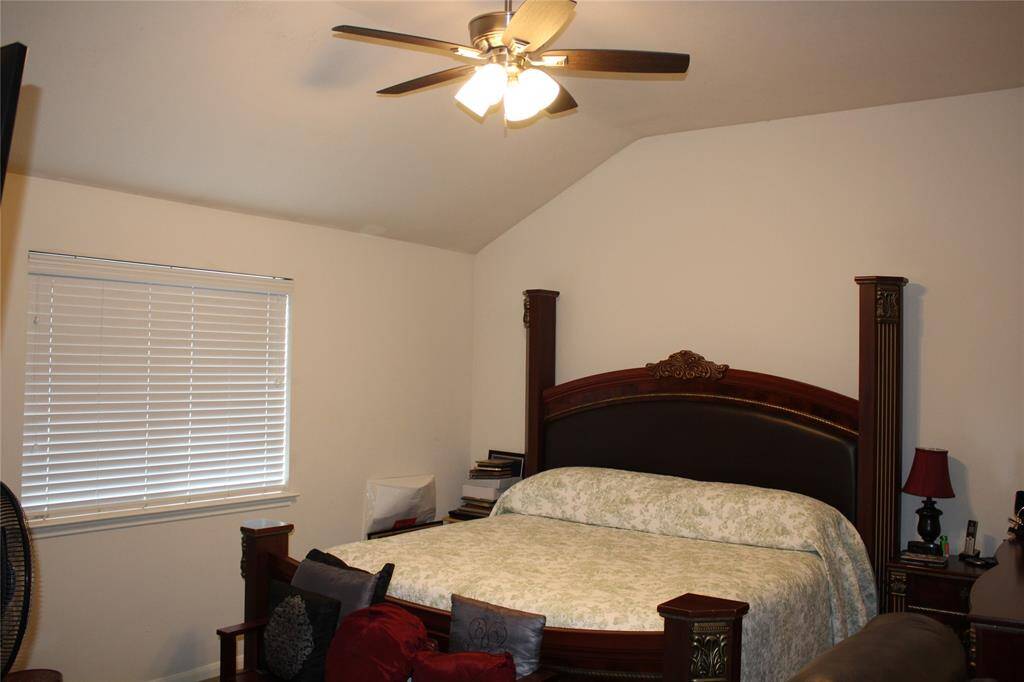 Primary bedroom has vaulted ceiling and ceiling fan.