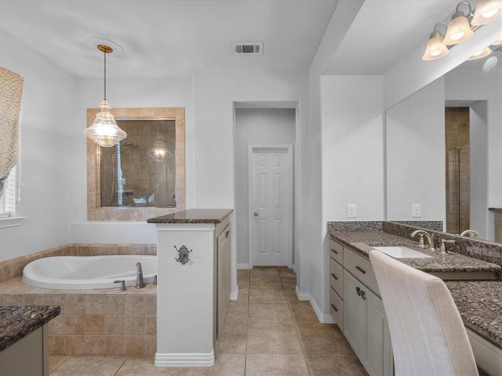 Primary Bathroom with tub and shower and His/Hers sinks