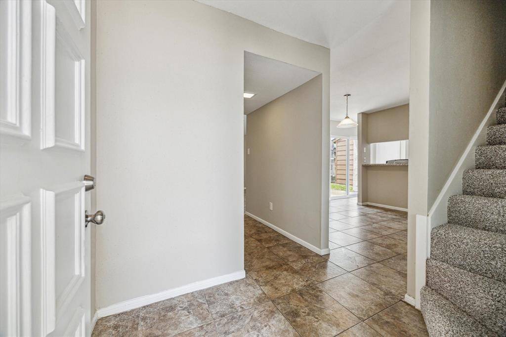 The entrance welcomes you into the foyer area with a view to the dining area and hallway to the half bath, and a view to the stairs.
