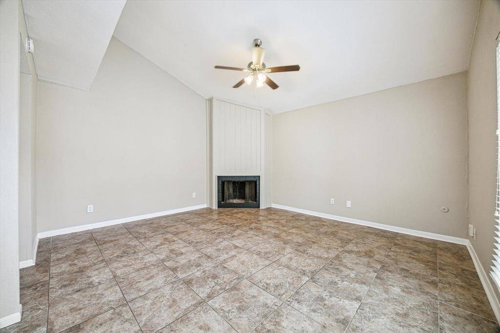 Experience the charm of a vaulted ceiling and cozy wood-burning fireplace in this inviting living space.
