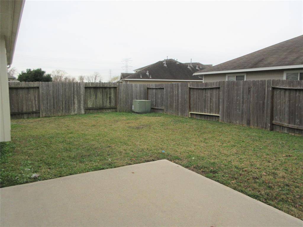 The House features a fenced backyard with a grassy area and a concrete patio, providing space for outdoor activities and relaxation.
