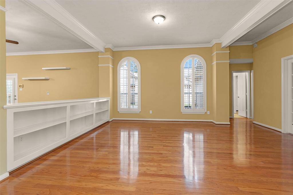 The home features Hardwood Floors, Crown Molding, Plantation Shutters on all Doors & Windows, & Elegant Arched Windows throughout!