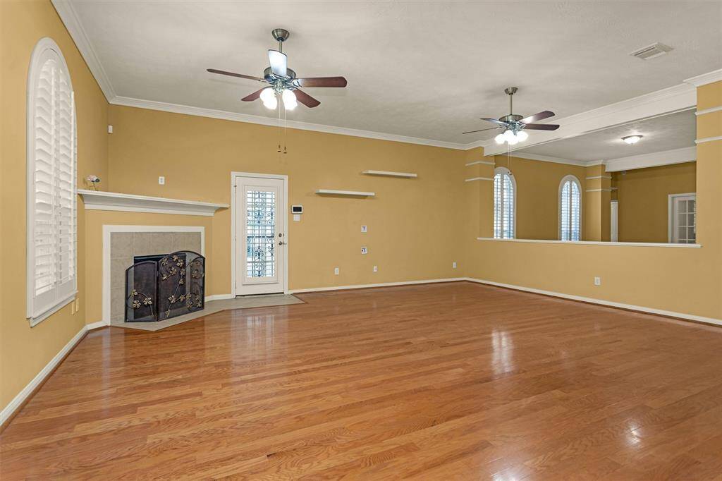 This Family Room features a ceiling fan, a cozy fireplace and a door for outdoor access!