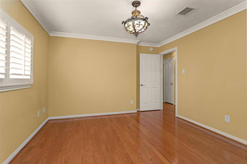 Bedroom #3 features hardwood flooring, a large window, Walk-In Closet and decorative chandelier!