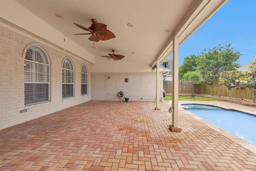The Backyard oasis features Sparkling Pool, Spa & Brick Pavered Covered Patio!