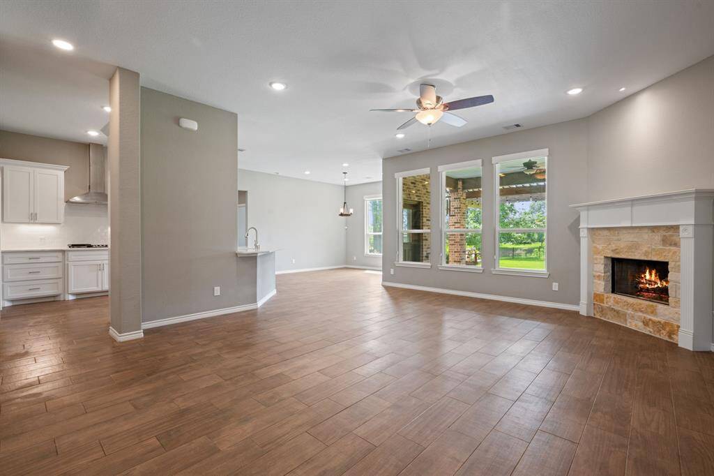 Spacious living room with corner fireplace and expansive windows that flood the home with natural light.