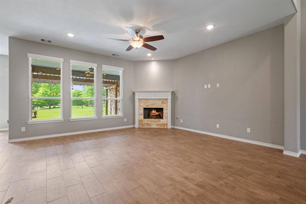 Cozy up by the stone-surround gas fireplace while enjoying serene views of the greenbelt and Lake Conroe Canal.