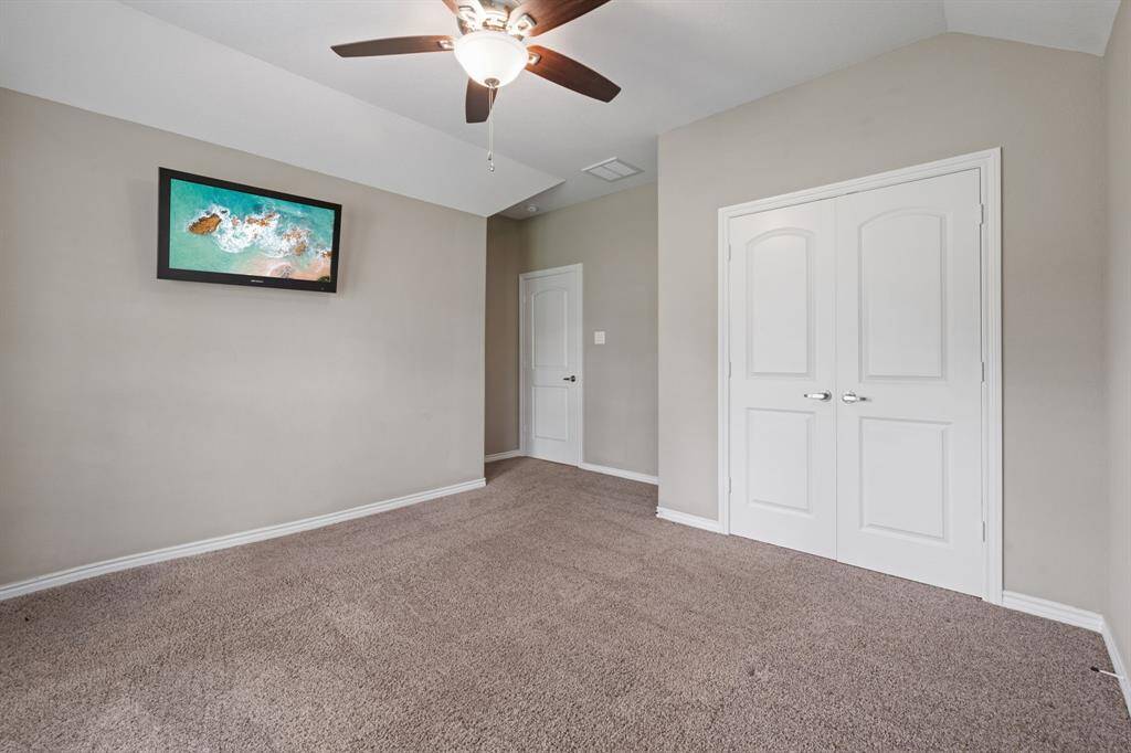 Spacious second guest room with mounted TV, generous closet space, and modern finishes.