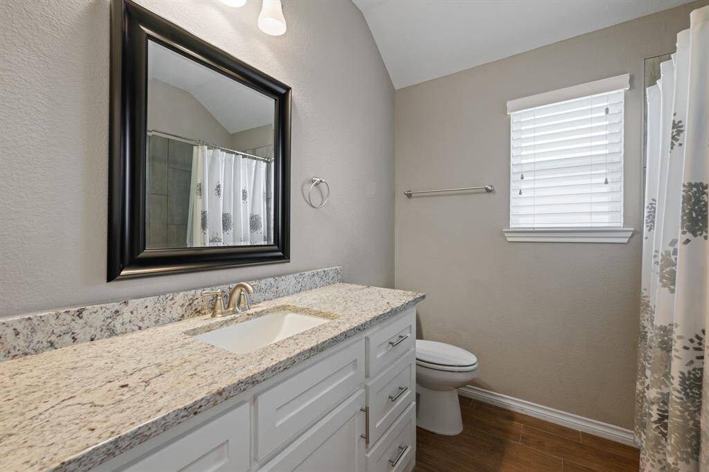 Another angle of the hall bath showcasing the walk-in shower/tub combo with modern tile surround and neutral tones throughout.