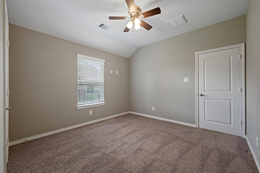 Alternate view highlighting the room's layout, neutral carpet, and walk-in closet with paneled doors.