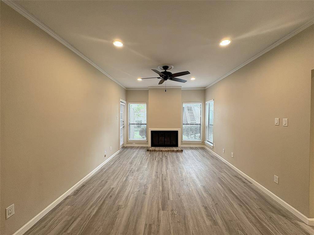 Three tall windows and a glass panel door in the living room bathe the living room in natural light.