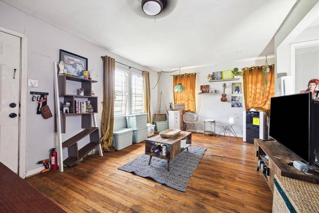 Living room features hardwood flooring, large window for natural light, and a pass-through to the kitchen