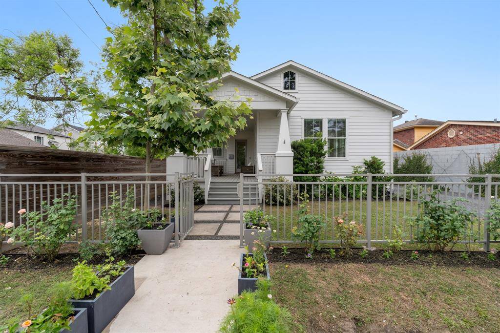 Set behind a gated entry, this beautifully landscaped front yard welcomes you with charming curb appeal and a spacious covered front porch. The walkway and greenery create a peaceful setting before you even step inside. Located in a walkable Heights neighborhood known for its tree-lined streets, local eateries, and tight-knit community charm.