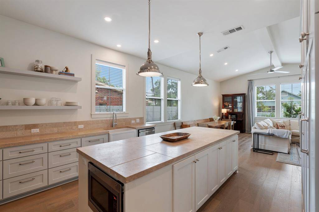 This open-concept kitchen, dining, and living space offers seamless flow and natural light, ideal for everyday living and effortless entertaining. Clean lines, neutral tones, and designer lighting create a cohesive and inviting atmosphere.