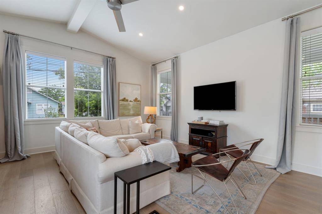The living room impresses with vaulted ceilings, expansive windows, and a spacious open concept perfect for everyday living or entertaining. Soft natural light and clean lines create an inviting environment.