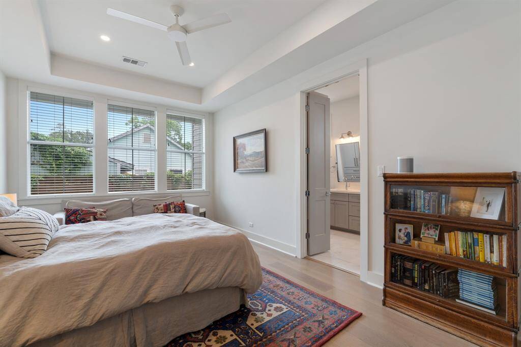 The expansive primary bedroom includes high ceilings and oversized windows that overlook the backyard. Direct access to the ensuite bath enhances the ease and flow of the room.