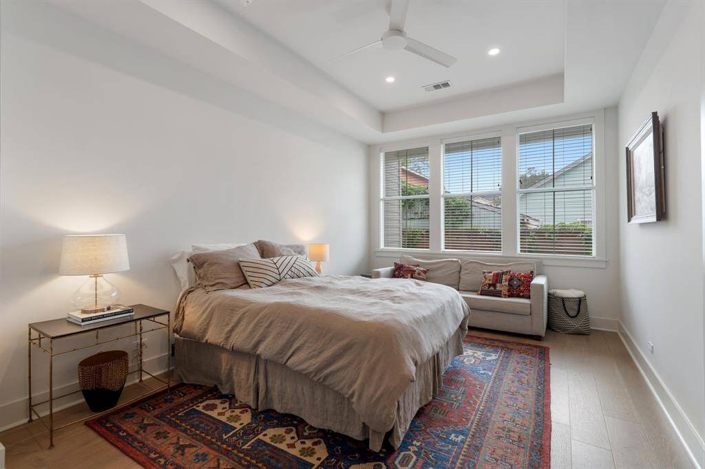 Another view of the primary bedroom reveals beautiful natural light and a relaxing sitting area. The clean architectural lines add to the calming atmosphere of the space.