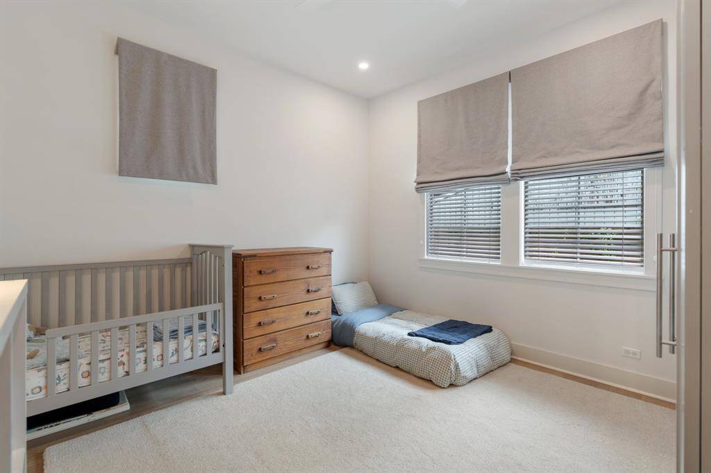 This spacious secondary bedroom features large windows that bring in abundant natural light. A neutral color palette and plush carpeting offer a comfortable retreat for rest or play.