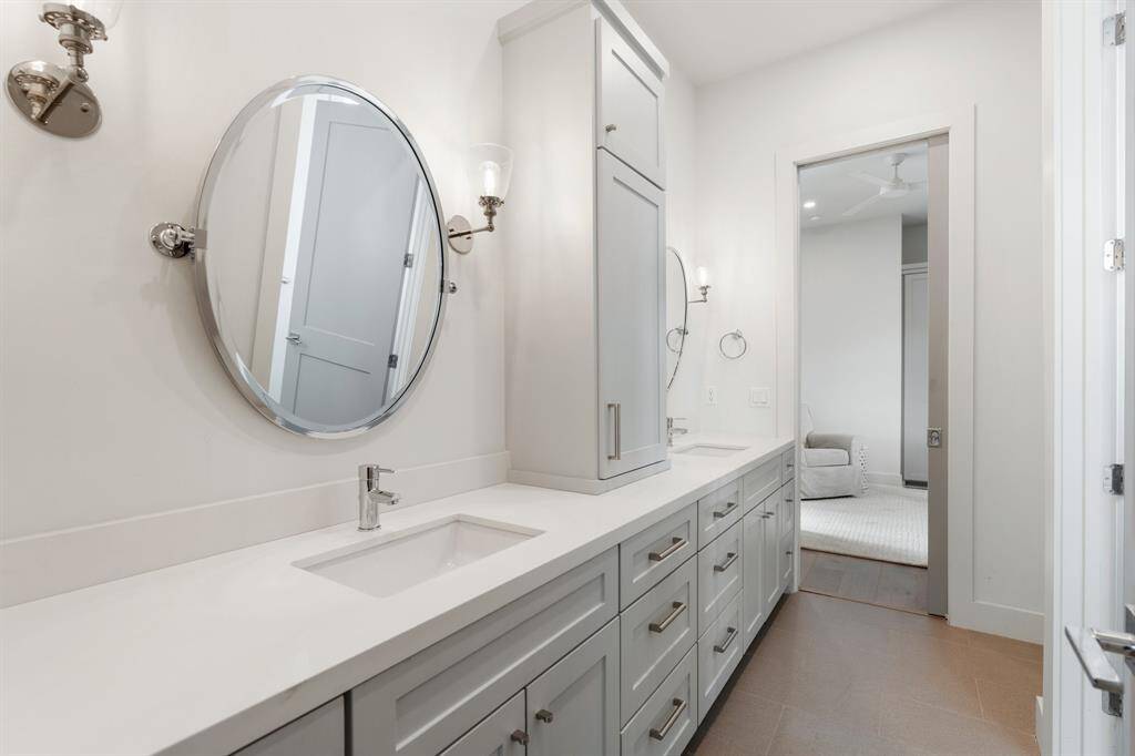 The Jack-and-Jill bathroom boasts a dual-sink vanity with generous cabinet storage and elegant lighting. Thoughtfully designed, this layout offers convenience and privacy between the secondary bedrooms.