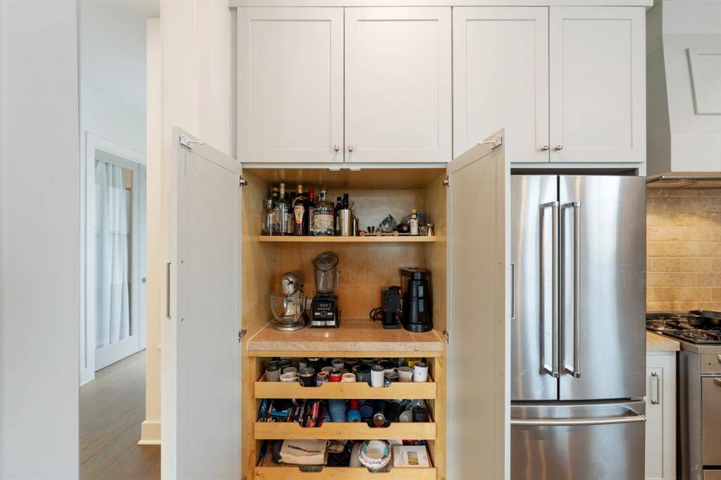 Tucked behind double doors, this hidden coffee or appliance nook offers built-in shelving and counter space for all your brewing or mixing essentials.