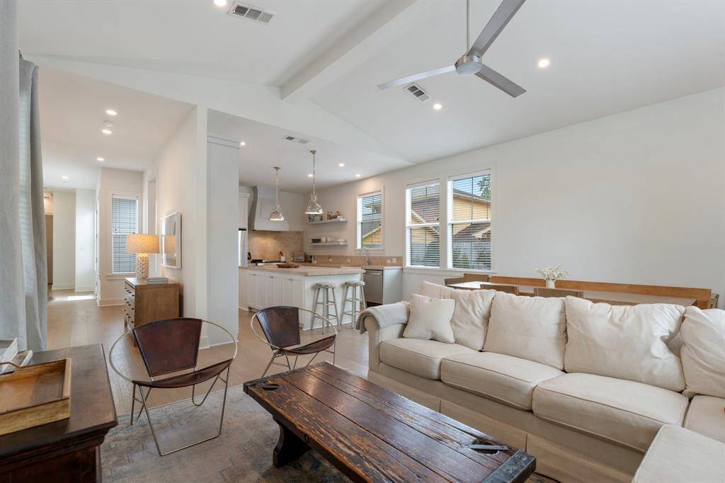 Enjoy seamless flow from the living room into the dining and kitchen areas, all under vaulted ceilings and surrounded by windows. This open concept layout is designed for both comfort and functionality.