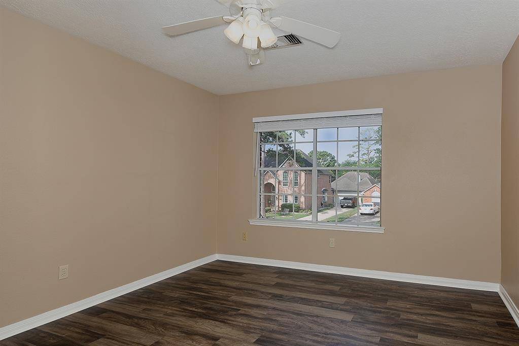 This bedroom has wood flooring & Custom Built-Ins by Closet