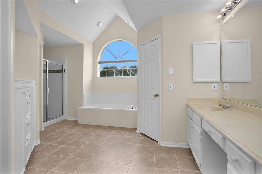 Tiled primary bathroom with loads of natural light