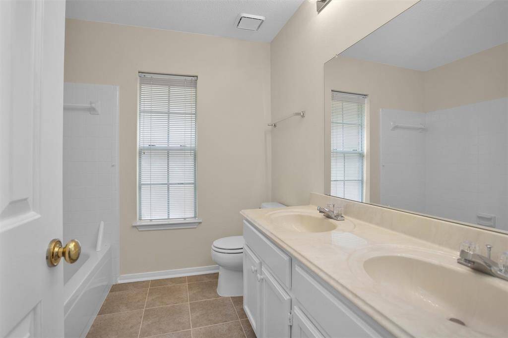 Hall bathroom has double sinks and combined tub/shower