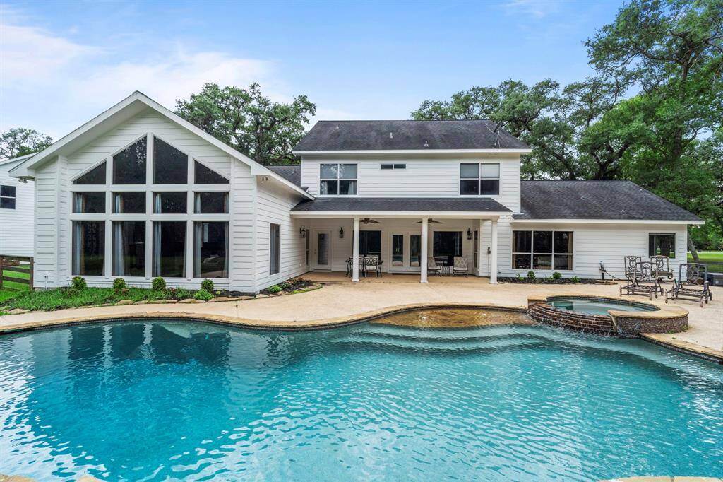 This stunning home features a spacious patio, and a beautiful swimming pool with a hot tub.