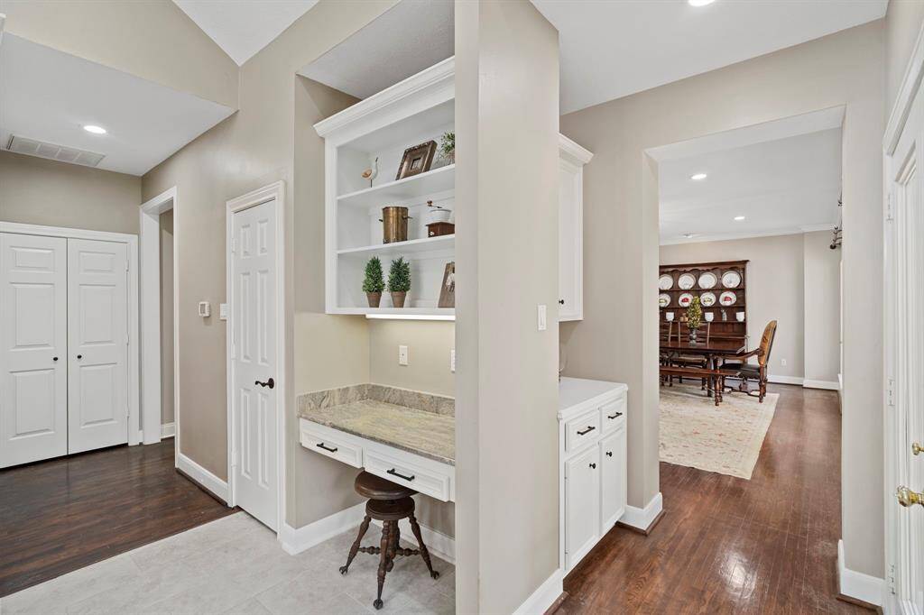 This versatile space features a sleek built-in desk with ample cabinetry for storage, ideal for managing schedules, sorting mail, or overseeing homework.