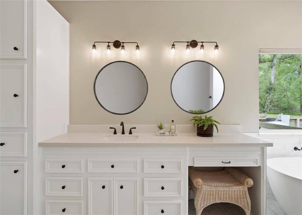 This elegantly designed bathroom vanity features crisp white cabinetry accented by sleek black stainless steel handles, creating a striking contrast and modern aesthetic.