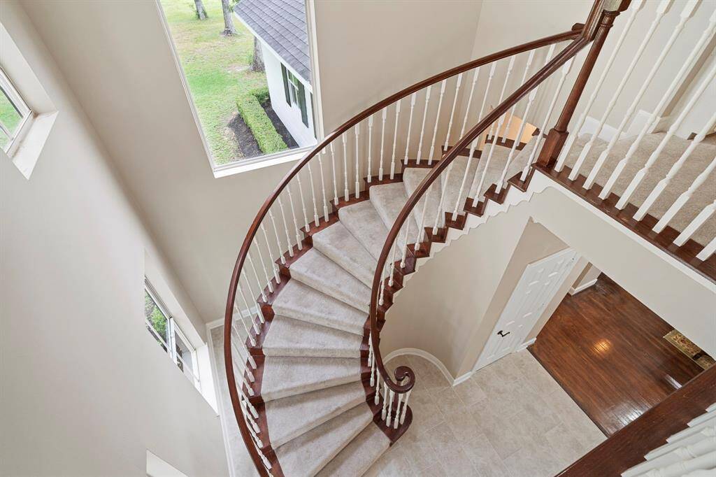 As you step into the foyer, you're immediately greeted by a sweeping staircase that gracefully curves to the upper level.