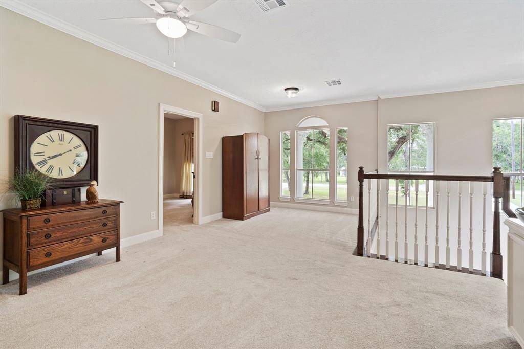 Bright, spacious upper-level with neutral tones, featuring a built-in desk area, cozy carpet, and ceiling fan. Ideal for a home office or lounge space.