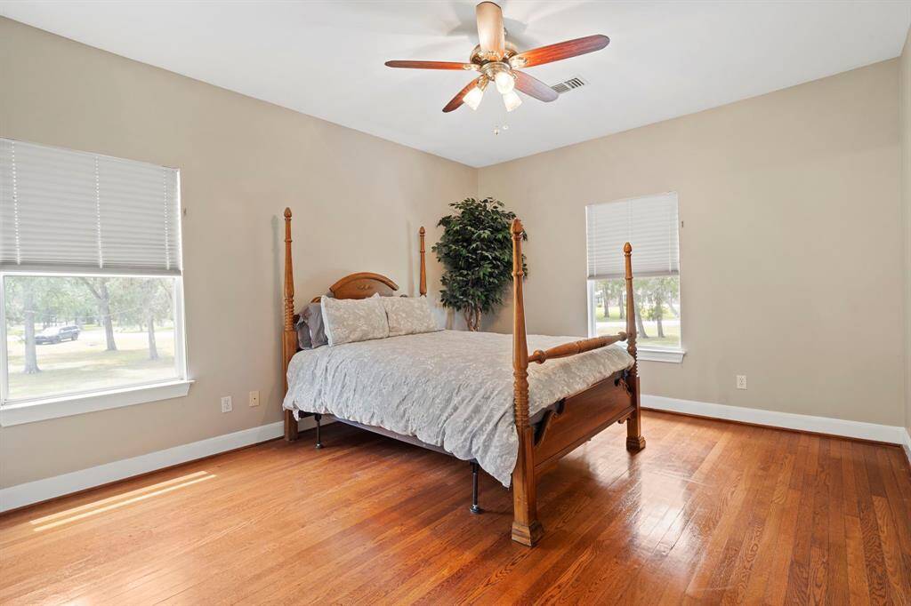 This spacious bedroom offers a warm and inviting retreat, featuring rich wood flooring that adds timeless character and elegance. The neutral-toned walls provide a versatile backdrop, ready to complement any style or décor.