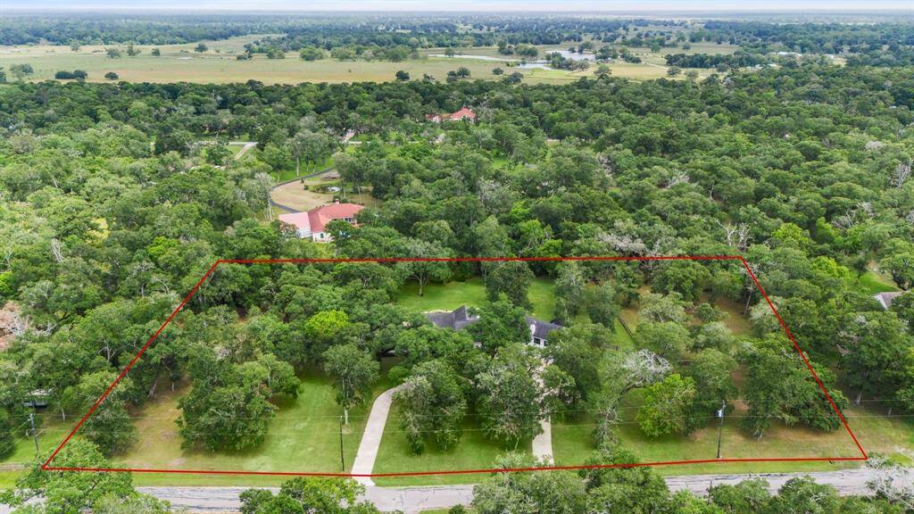 Expansive, lush green yard with mature trees, offering ample space and a serene, natural setting, perfect for outdoor activities and relaxation.