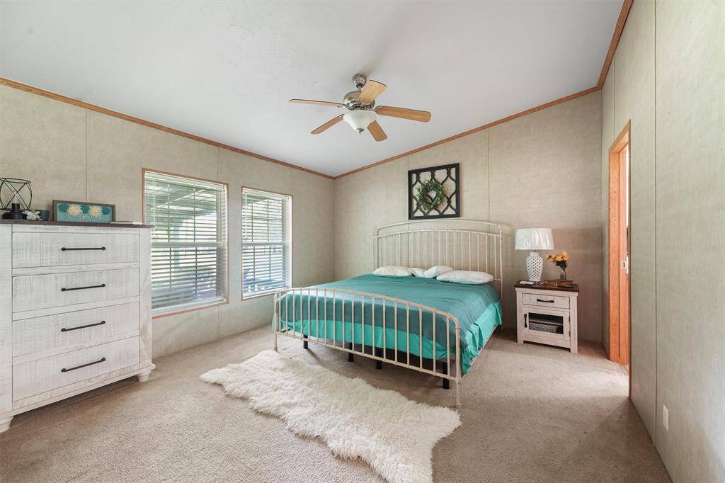 Primary Bedroom with a window looking out to the front yard.