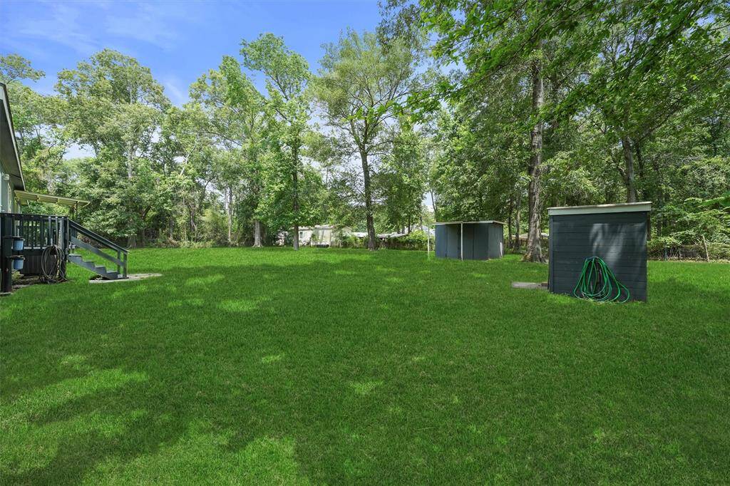 Looking from right side of home towards the back of property. Property is fenced on three sides. Property has a well house and storage building.