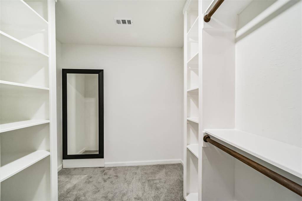 Walk-in closet with climate controlled storage/playroom behind the mirror