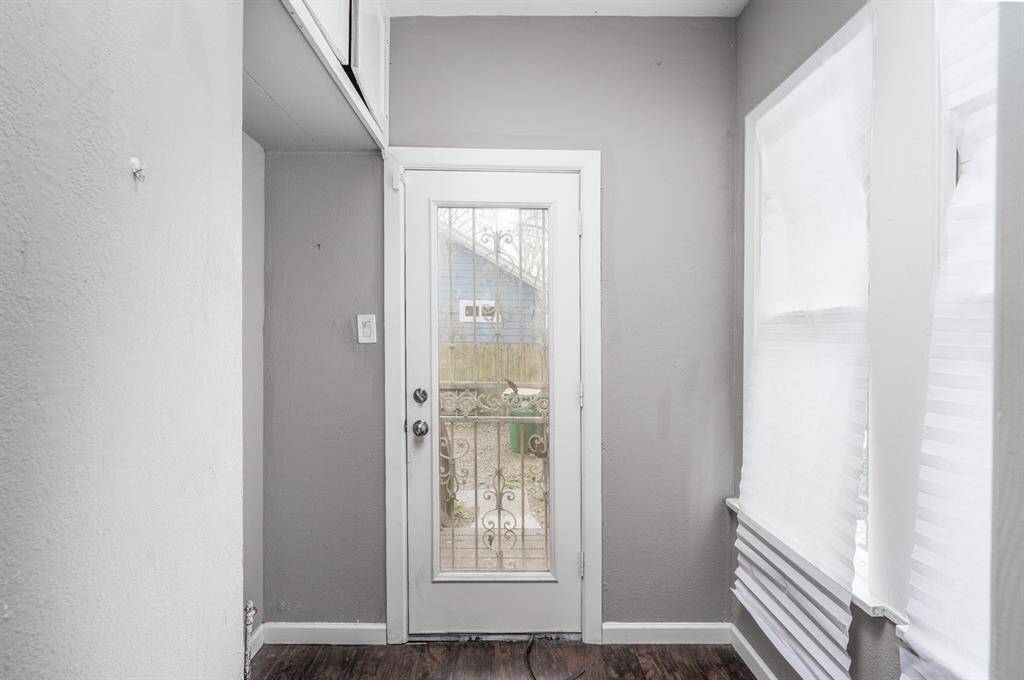 Utility room off of kitchen with access to parking and backyard.