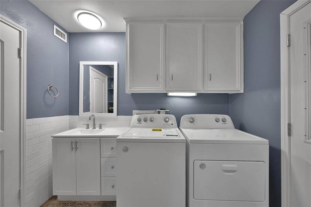 Utility room with plenty of cabinet storage plus a sink and half bath!