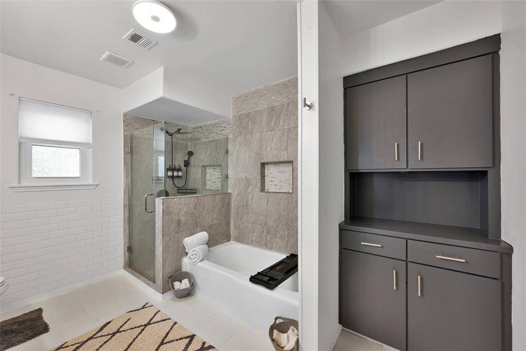 Primary bath with built in storage, walk-in-shower and soaking tub.
