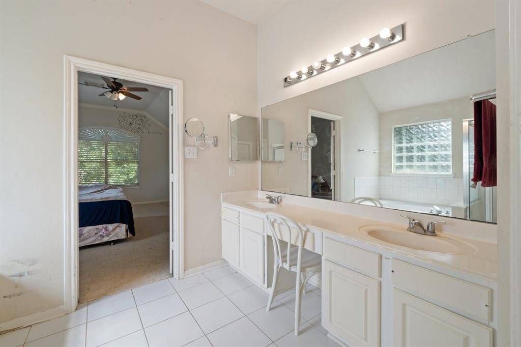 Master bathroom with dual sinks and vanity area.
