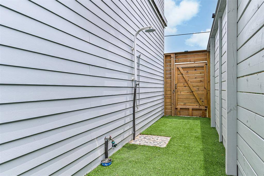 Outdoor shower with surrounding turf.