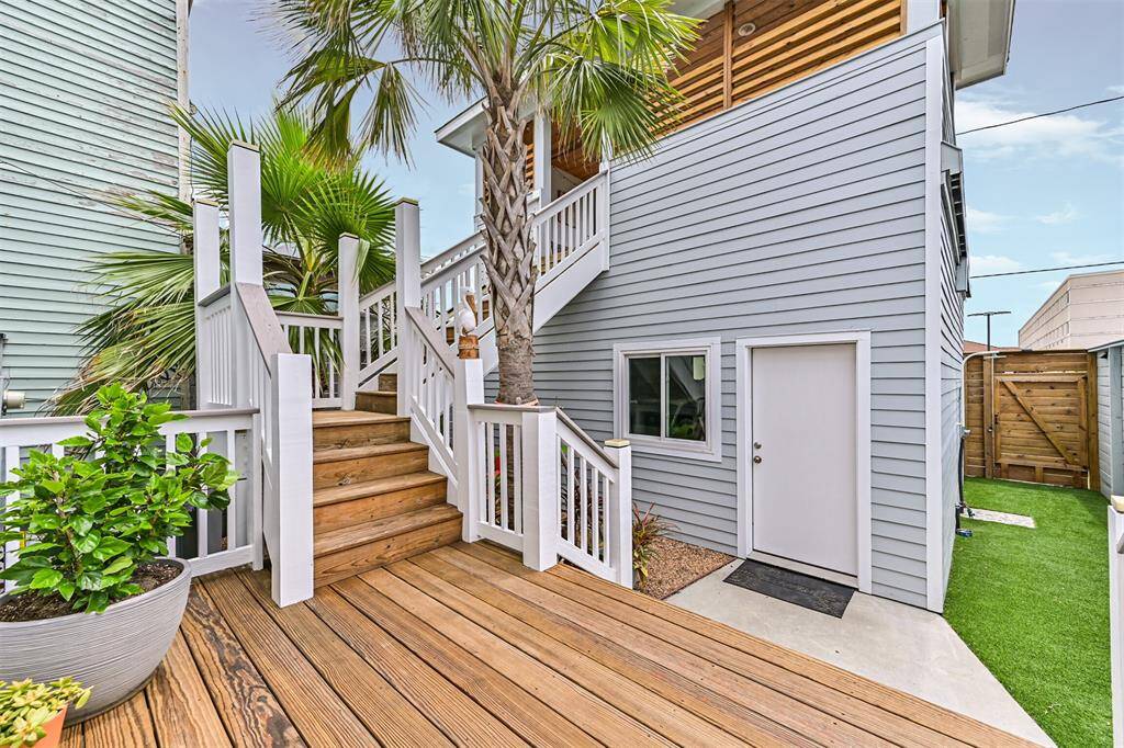 The secondary structure houses a two-car garage and rooftop deck with ocean views.