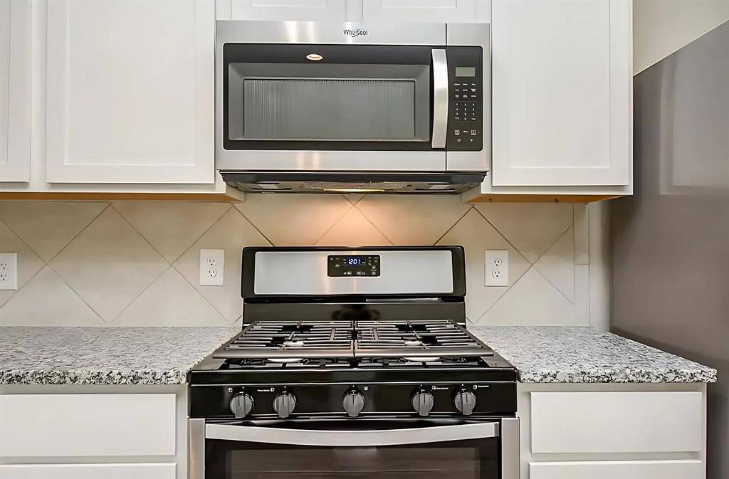kitchen equipped with a Whirlpool 5.1 Cu. Ft. Freestanding Gas Range and built-in microwave.