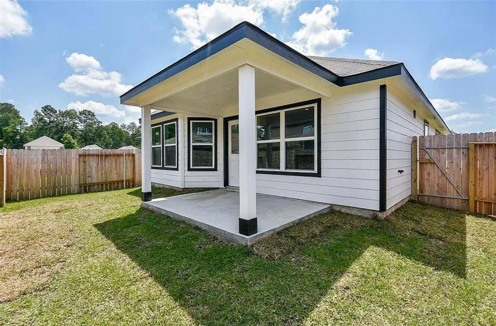 Another view of the backyard with a covered patio, perfect for family living all in a prime location.